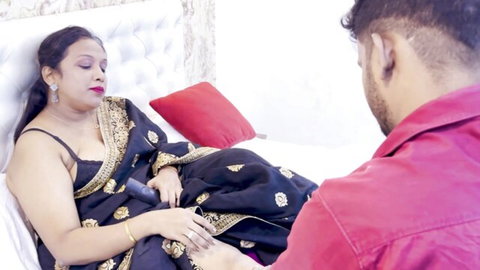 Desi Indian landlady in black saree shows cleavage, submissive pose with young man