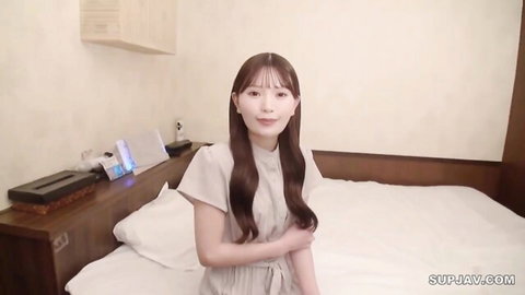 Seductive Asian nail artist in short dress, smiling on bed, solo tease