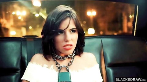 Seductive brunette in limo teases with tongue out, deep cleavage and padlock necklace