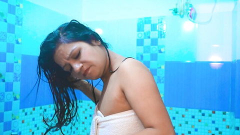 Wet South Asian girl in white towel showing cleavage after shower in bathroom