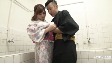 Japanese MILF in pink floral kimono embraces man in black yukata in steamy bathroom