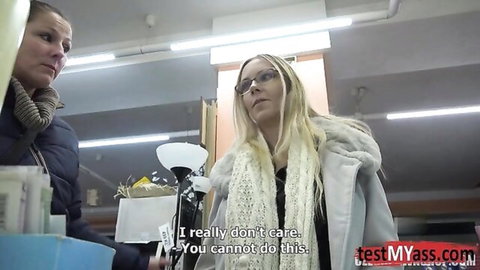 Blonde woman in glasses argues with brunette in supermarket aisle
