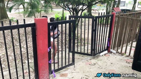 Sexy nude South Asian woman teases bare ass at outdoor park gate with purple hip ribbons