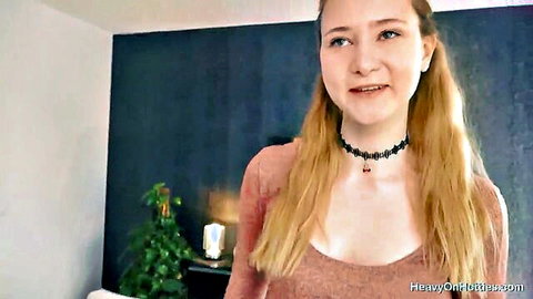 Blonde Ivi Rein in choker, smiling with cleavage in pink top
