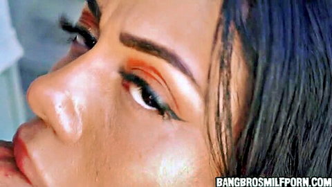 Seductive close-up of Latina MILF maid with bold makeup and sultry gaze