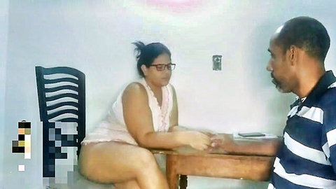 Chubby Latina with glasses in tight pink top and shorts chats intimately with black stud at table