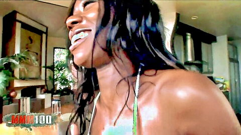 Smiling small ebony goddess in green bikini, wet hair, teasing vibe