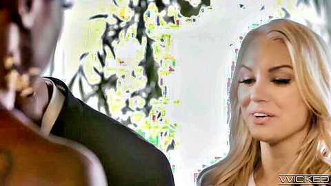 Blonde in white dress seduces black suited man in intimate garden pose
