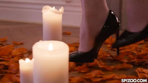 Jenny Wild's seductive leg in black high heels on orange petals, romantic tease