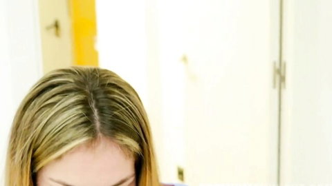 Closeup of sexy blonde with highlighted streaked hair looking down in bedroom.
