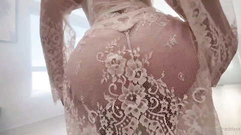 Woman in sheer white lace lingerie bending over exposing her round ass cheeks from behind
