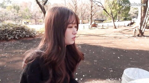 Asian woman with long brown hair in autumn park, black top, JAV softcore tease