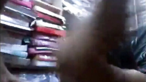 Blurry bookshelves in low light, no explicit content visible