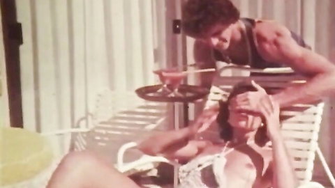 Vintage poolside tease with petite bikini babe covering eyes as muscular hunk pours cocktail behind her