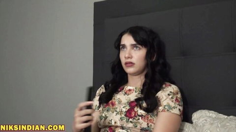 Surprised brunette stepsis in floral dress on bed, teasing bi-racial stepbro encounter
