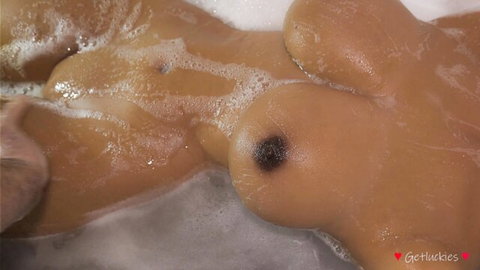 Curvy ebony woman in steamy bubble bath, large breasts exposed