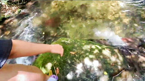 Hot Latina in outdoor stream scene, teasing touch on mossy rocks