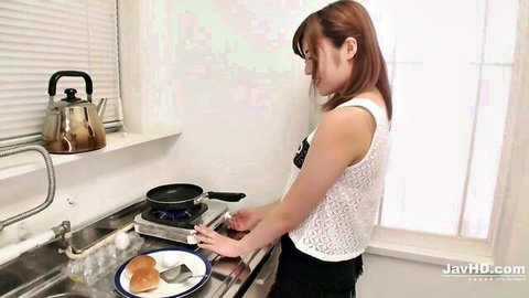 Yumi Maeda cooking in kitchen wearing white tank top and black shorts