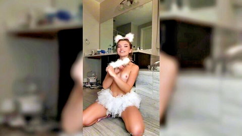 Petite tiny tits girl kneels topless in fluffy white cat ears tutu exposing perky breasts