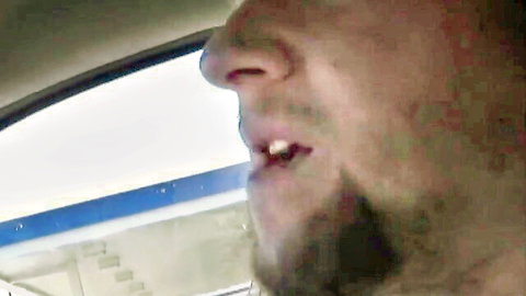 Close-up of bearded man with open mouth inside car window during day