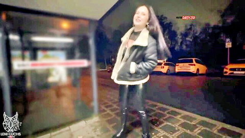Leni-Luchs posing seductively in open shearling jacket and tight leather pants at night bus stop