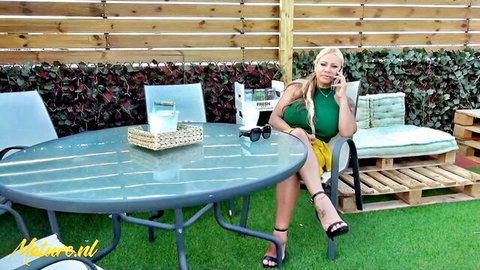 Curvy buxom blonde mature in green dress, teasing outdoors