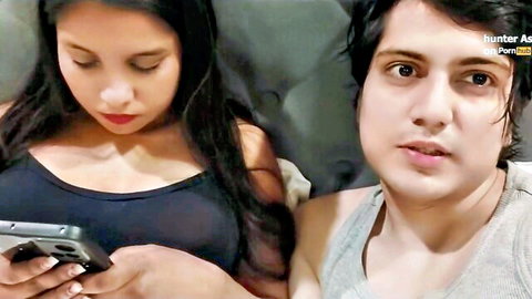 Hunter Asia with stepsis in intimate bedroom pose, black tank top cleavage