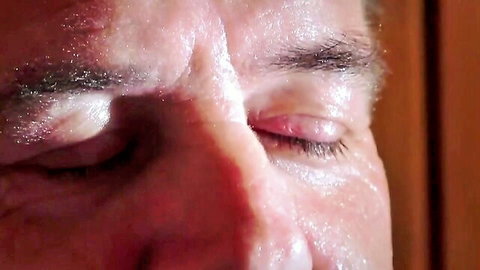 Close-up of man's teary eyes gagging during virgin blowjob