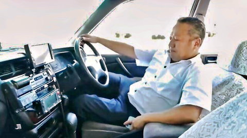 Asian taxi driver man relaxed in car seat, outdoor drive