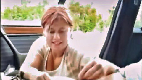 Chubby redhead smiles as man's hand gropes her big tits in parked car on public street