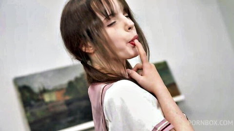 Dakota Doll teases with finger in mouth, seductive schoolgirl pose
