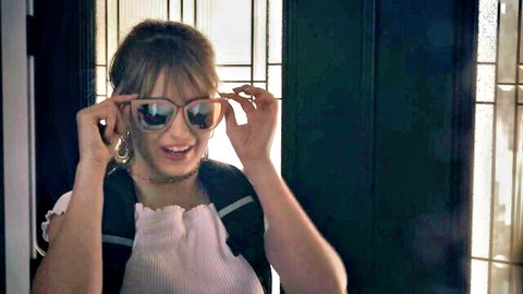 Ivy Wolfe smiling excitedly in sunglasses and white top