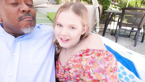 Coco Lovelock cuddles with older black man in floral top outdoors