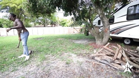 Muscular black gardener King Louie posing outdoors with shovel