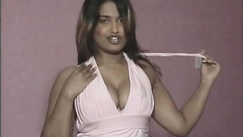 Curvy Indian woman measuring her huge cleavage in pink halter top