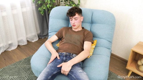 Hot 18yo twink lounging in jeans, hand on crotch, teasing massive dick bulge