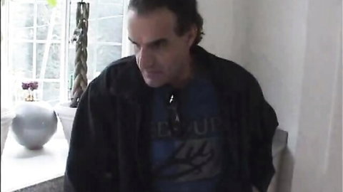 Intense man in leather jacket and Gear Up shirt, indoor setting