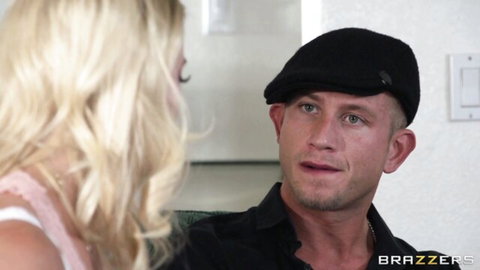 Blonde babe in pink top chats intimately with handsome guy in black hat on couch
