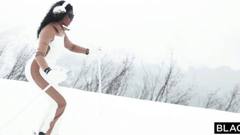 Sexy ebony skier in skimpy white thong bodysuit showing curves on snowy slope