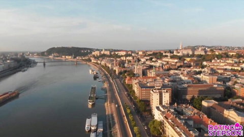 Aerial drone view of Budapest skyline along Danube River at sunset with Dating Stepson watermark