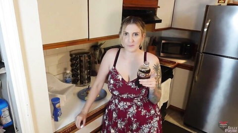 Kelly Payne in low-cut floral dress teasing with Coke bottle