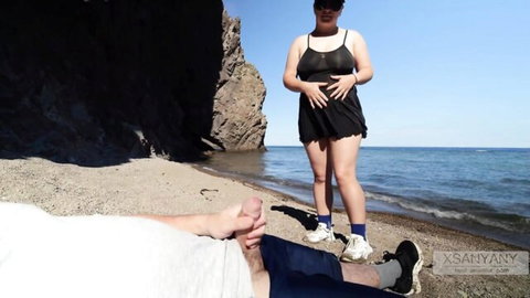 Hot curvy blonde in black mini dress watches guy jerk off on sunny beach