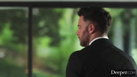 Handsome suited man in black suit gazes sideways through window in Deeper porn video