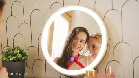 Leona Mia and Kelly Collins smiling playfully in mirror