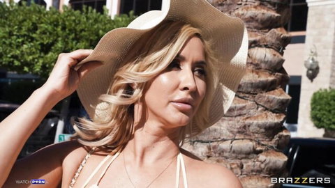 Isis Love as blonde MILF in white bikini and hat, big tits at sunny spa