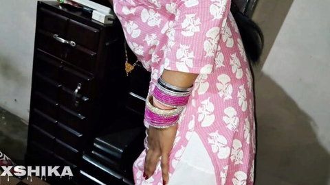 Sexy Indian Bhabhi in pink floral dress with bangles, teasing in traditional attire