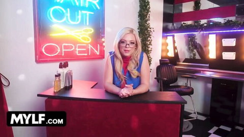 Blonde MILF with glasses smiles seductively at salon counter teasing her perfect tits