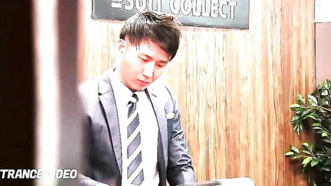 Handsome Asian man in suit standing at Soul Collect desk counter