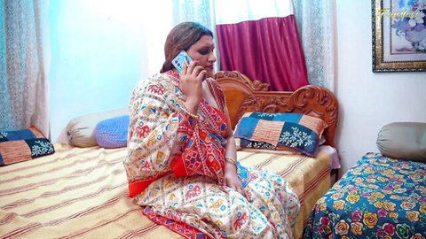 Sexy Indian housewife in colorful saree talking on phone seductively on bed