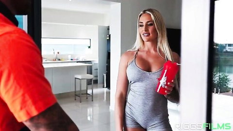 Busty blonde with huge tits in tight gray bodysuit holds red cup teasing muscular black stud in kitchen